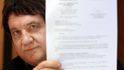 L'ancien inspecteur des imp&ocirc;ts R&eacute;my Garnier, le 22 d&eacute;cembre 2009, montre&nbsp;sa demande de r&eacute;int&eacute;gration au service des imp&ocirc;ts, &agrave; Agen (Lot-et-Garonne). (JEAN-MICHEL MAZET / AFP)