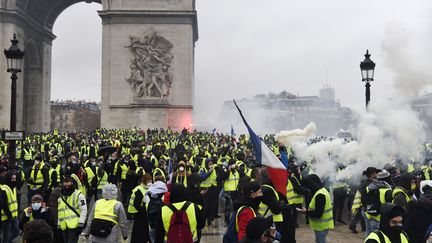 Des "gilets jaunes" vendalisent l'Arc de Triomphe, l'un des lieux touristiques de Paris, le 1er décembre 2018. (LUCAS BARIOULET / AFP)