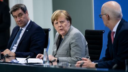 La chancelière allemande, Angela Merkel, tient une conférence de presse sur le coronavirus, entourée du ministre-président de Bavière, Markus Söder, et du premier bourgmestre de Hambourg, Peter&nbsp;Tschentscher, le 15 avril 2020 à Berlin. (BERND VON JUTRCZENKA / DPA / AFP)