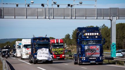 Des routiers d&eacute;filent sous un portique &eacute;cotaxe, le 9 novembre 2013, pr&egrave;s de Martigues (Bouches-du-Rh&ocirc;ne). (BERTRAND LANGLOIS / AFP)