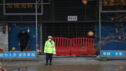 Un policier devant le marché aux poissons fermé de Wuhan (Chine), le 10 janvier 2020. (DARLEY SHEN / REUTERS)