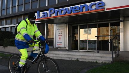 Un cycliste passe devant les locaux marseillais de "La Provence", le 15 février 2022. (CHRISTOPHE SIMON / AFP)