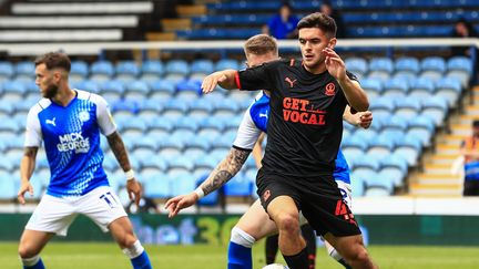 Le footballeur Jake Daniels (en noir) à Londres (Grande-Bretagne) lors du match opposant Blackpool à Peterborough United, le 7 mai 2022. (LEE PARKER - CAMERASPORT / CAMERASPORT via GETTYIMAGES)