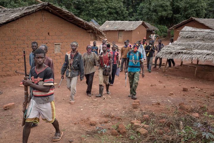 Hommes appartenant aux groupes anti-balaka en train de marcher près de Gambo (sud-est de la Centrafrique) le 13 mai 2017. (ALEXIS HUGUET / AFP)