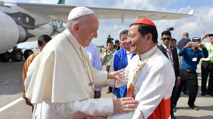 Le pape François accueilli par le cardinal Charles Maung Bo, archevêque de Rangoun, sur le tarmac de l’aéroport de Rangoun, en Birmanie, le 27 novembre. (AFP / OSSERVATORE ROMANO)