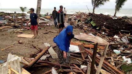 Des résidents de Carita (Indonésie) inspectent les débris sur la plage après le tsunami, le 23 décembre 2018. (SEMI / AFP)