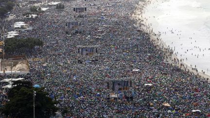 Des fid&egrave;les sont mass&eacute;s sur la plage de Copacabana &agrave; Rio de Janeiro (Br&eacute;sil) pour assister &agrave; la messe de cl&ocirc;ture des Journ&eacute;es Mondiales de la Jeunesse c&eacute;l&eacute;br&eacute;e par le pape Fran&ccedil;ois, le 28 juillet 2013. (© PAULO WHITAKER / REUTERS / X00921)