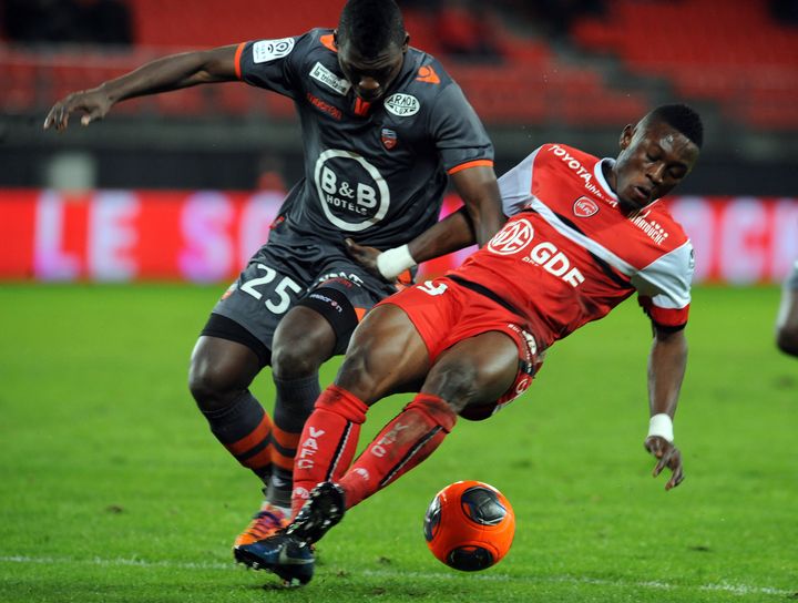 Le joueur de Valenciennes Waris Majeed (en rouge) aux prises avec le d&eacute;fenseur de Lorient Lamine Gassama, le 25 janvier 2014.&nbsp; (FRANCOIS LO PRESTI / AFP)