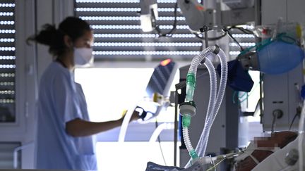 Une soignante prend en charge en soins intensifs un patient à Mulhouse (Haut-Rhin), le 23 juillet 2021. (SEBASTIEN BOZON / AFP)