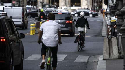 Une femme fait du vélo à Paris, le 23 septembre 2020. (CHRISTOPHE ARCHAMBAULT / AFP)