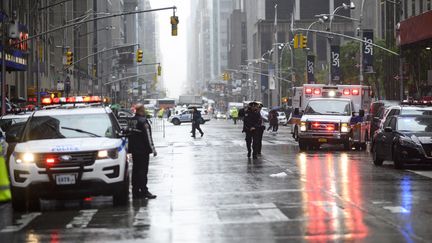 Des policiers et des pompiers à Manhattan, un quartier de New York, après le crash d'un hélicoptère sur un immeuble, le 10 juin 2019. (JOHANNES EISELE / AFP)