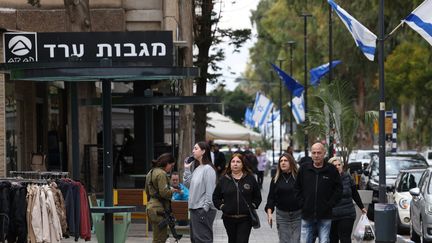 Des personnes marchent dans une rue de Nahariya, dans le nord d'Israël, le 27 novembre 2024, après l'entrée en vigueur d'un cessez-le-feu entre Israël et le Hezbollah. (AHMAD GHARABLI / AFP)