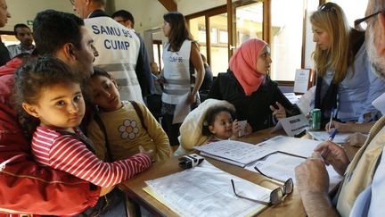 Des migrants syriens et irakiens discutent avec des m&eacute;decins &agrave; leur arriv&eacute;e dans un centre d'h&eacute;bergement de Cergy-Pontoise (Val-d'Oise), le 9 septembre 2015. (JACKY NAEGELEN / REUTERS)