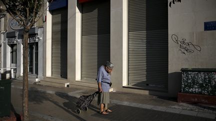 Une femme devant une banque ferm&eacute;e &agrave; Ath&egrave;nes (Gr&egrave;ce), le 29 juin 2015. (ALKIS KONSTANTINIDIS / REUTERS)