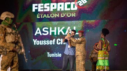 Le président de transition du Burkina Faso, le capitaine Ibrahim Traoré, remet l'Etalon d'or au représentant du réalisateur tunisien Youssef Chebbi, à Ouagadougou, le 4 mars 2023. (OLYMPIA DE MAISMONT / AFP)