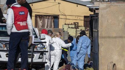 Les forces de l'ordre et le service médico-légal inspectent la scène d'une fusillade de masse à Soweto, en Afrique du Sud, le 10 juillet 2022. (IHSAAN HAFFEJEE / ANADOLU AGENCY / AFP)