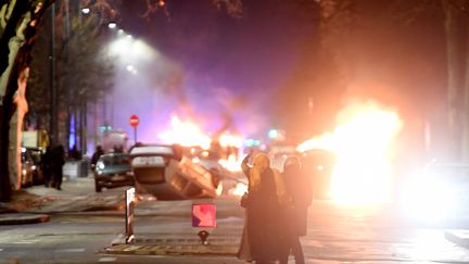 Des voitures incendiées et retournées dans le quartier Mistral à Grenoble (Isère), le 6 mars 2018. (JEAN-PIERRE CLATOT / AFP)