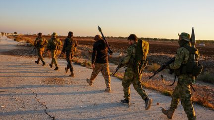 Des soldats de groupes rebelles sur une route près de la ville d'Alep, en Syrie, le 1er décembre 2024. (RAMI ALSAYED / NURPHOTO / AFP)