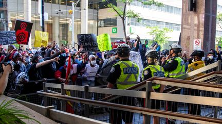 "Arrêtez de nous tuer" peut-on lire sur une des pancartes brandies par les manifestants face à la police de Toronto (Canada), le 30 mai 2020.&nbsp; (CARLOS OSORIO / REUTERS)