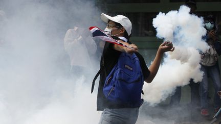 Un manifestant antigouvernemental envoie des gaz sur les forces de l'ordre, le 1er d&eacute;cembre 2013 &agrave; Bangkok (Tha&iuml;lande).&nbsp; (CHAIWAT SUBPRASOM / REUTERS)