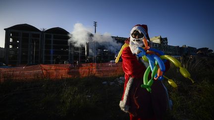 Un migrant, grimé en Père Noël, évacué le 10 décembre 2018 d'une usine de pénicilline désaffectée où il avait trouvé un abri avec d'autres migrants d'origine africaine mais aussi avec des familles italiennes précaires. (FILIPPO MONTEFORTE / AFP)