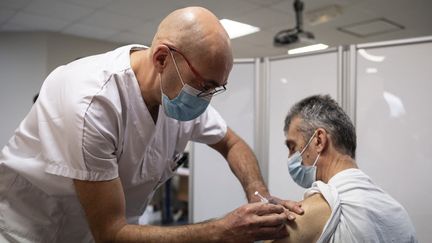 Un soignant reçoit une dose d'un vaccin contre le Covid-19, le 12 janvier 2021 à Annonay (Ardèche). (BASTIEN DOUDAINE / HANS LUCAS)