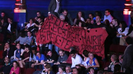 Des membres du collectif&nbsp;"La Chapelle-Austerlitz" d&eacute;ploient une banderole pendant le meeting du PS consacr&eacute; aux r&eacute;fugi&eacute;s, mardi 8 septembre 2015 &agrave; Paris.&nbsp; (JACQUES DEMARTHON / AFP)