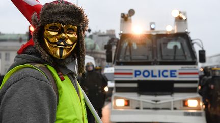 Un manifestant devant un camion de police, le 5 janvier à Paris.&nbsp; (BERTRAND GUAY / AFP)