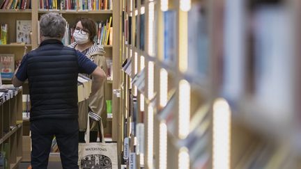 Une femme portant un masque dans une librairie de Mulhouse (Haut-Rhin), le 11 mai 2020. (SEBASTIEN BOZON / AFP)