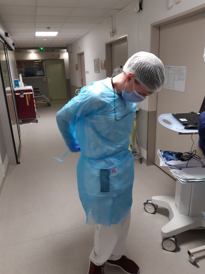 Une personne&nbsp;revêt sa blouse de protection&nbsp;aux&nbsp;urgences de Mulhouse, dans la partie qui accueille les cas probables de coronavirus. (JÉRÔME JADOT / RADIO FRANCE)