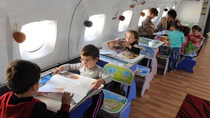 Des enfants jouent dans un avion sovi&eacute;tique converti en cr&egrave;che, le 29 octobre 2012 &agrave; Roustavi (G&eacute;orgie). (VANO SHLAMOV / AFP)