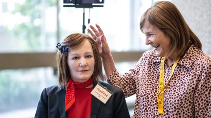 Nadia Thalmann, professeure en informatique à l’Université de Genève, aux côtés de son robot "Nadine". (FABRICE COFFRINI / AFP)