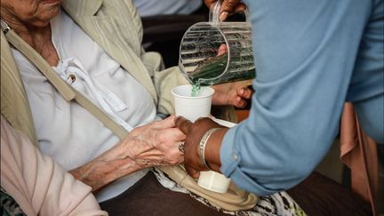 Une personne âgée reçoit un verre de sirop et d'eau, dans un Ehpad à Paris, lors d'un épisode de canicule, en juin 2019. (MAXPPP)