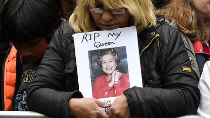 Une femme attend le long de la route empruntée par le cercueil de la reine Elisabeth II à Londres (Royaume-Uni), le 19 septembre 2022. (LOUISA GOULIAMAKI / AFP)