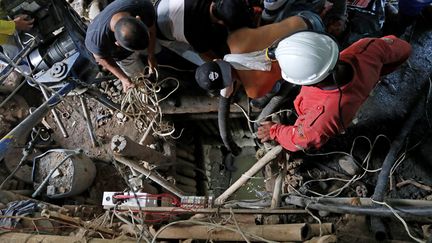 Des pompiers et des secouristes à la recherche de onze mineurs bloqués dans un puits, le 17 mars 2021 à Neira (Colombie). (JOHN BONILLA / AFP)