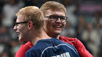 Félix Lebrun (à gauche) célèbre avec son frère Alexis Lebrun la médaille de bronze obtenue pour l'équipe de tennis de table lors des Jeux olympiques de Paris 2024, le 9 août 2024. (JUNG YEON-JE / AFP)