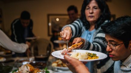 Une famille partage un repas de Thanksgiving, le 26 novembre 2020, à Los Angeles (Californie). (BRANDON BELL / GETTY IMAGES NORTH AMERICA / AFP)