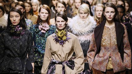 Dries Van Noten a proposé une foisonnante collection ultra-féminine qui fait la part belle aux broderies et imprimés. Pour les pantalons toujours amples, parfois à traîne intégrée, comme pour les robes, la fluidité et le confort sont privilégiés, déclinant notamment l'esprit de la saharienne militaire confortable et pratique. Le créateur belge propose aussi de longs manteaux damassés, d'autres auréolés de fourrures synthétiques, des pulls et blouses brodés d'or, des vestes à la taille appuyée, des jupes portefeuilles en toile de coton.
 (PATRICK KOVARIK / AFP)