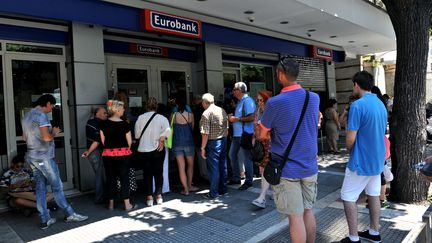 Des personnes patientent devant une agence bancaire, le 6 juillet 2015, &agrave; Thessalonique (Gr&egrave;ce). (SAKIS MITROLIDIS / AFP)