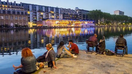 Des Parisiens au bord du bassin de la Villette, dans le 19e arrondissement, le 7 mai 2018. (GARDEL BERTRAND / AFP)