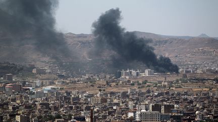 De la fum&eacute;e s'&eacute;l&egrave;ve pr&egrave;s de la facult&eacute; de sciences et de technologie, &agrave; Sanaa (Y&eacute;men), o&ugrave; chiites et sunnites se livrent &agrave; des violents combats. (MOHAMMED HUWAIS / AFP)