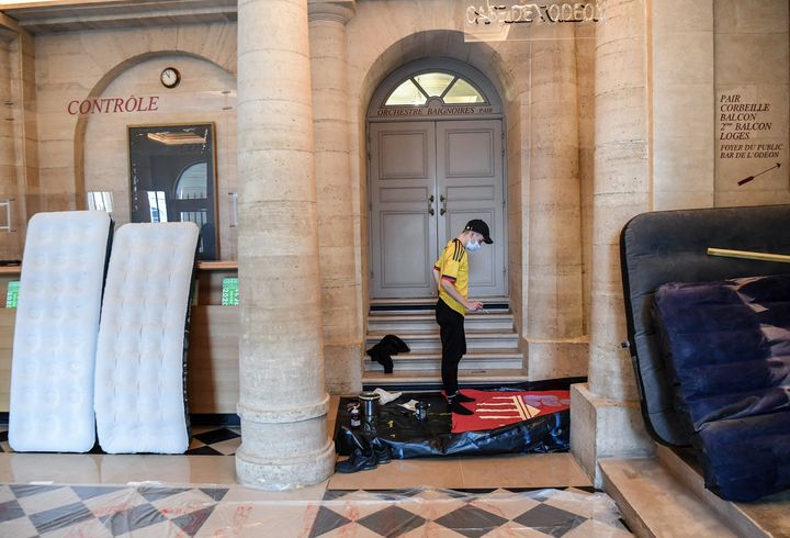 Manifestant à l'intérieur du théâtre de l'Odéon à Paris, occupé par les intermittents, le 25 mars 2021 (ALAIN JOCARD / AFP)