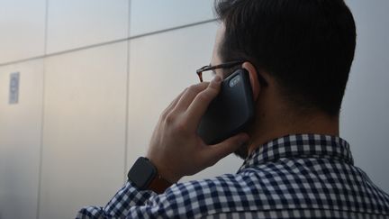 Un homme au téléphone. (JEAN-CHRISTOPHE BOURDILLAT / FRANCE-INFO)