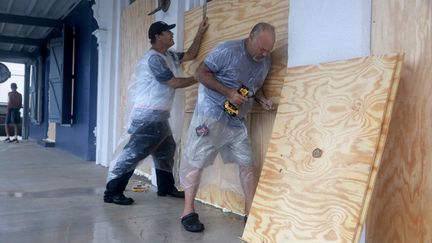 Residents of Cedar Key, Florida, protect the windows of a store before Hurricane Debby hits on August 4, 2024. (JOE RAEDLE / GETTY IMAGES NORTH AMERICA / AFP)