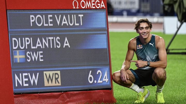 Le perchiste Armand Duplantis pose à côté de l'écran affichant son nouveau record du monde, le 20 avril 2024, à Xiamen (Chine). (STR / AFP)