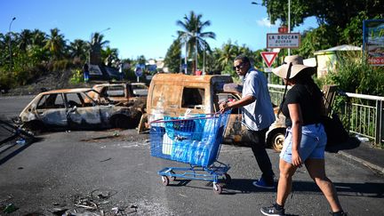 Un homme pousse un chariot rempli de bouteilles d'eau, à Sainte-Rose (Guadeloupe), le 29 novembre 2021.&nbsp; (Christophe ARCHAMBAULT / AFP)