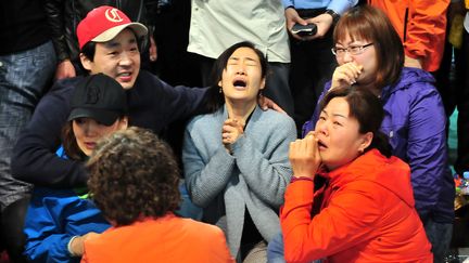 Des familles se recueillent dans un gymnase de Jindo, le 17 avril 2014, au lendemain du naufrage du "Sewol".&nbsp; (JUNG YEON-JE / AFP)