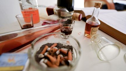 Une table couverte de mégots de cigarette, de bouteilles et de verres renversés que l'on peut voir au Musée de la gueule de bois, ouvert le 1er décembre 2019 à Zagreb (Croatie). (DENIS LOVROVIC / AFP)