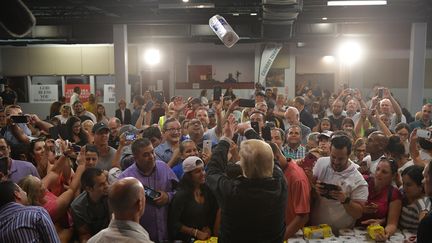 Le président américain, Donald Trump, lance des rouleaux d'essuie-tout dans l'assistance, à Porto Rico, le 3 octobre 2017. (MANDEL NGAN / AFP)