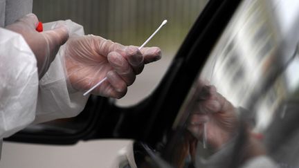 Un personnel soignant effectue un test PCR de dépistage du coronavirus le 31 juillet 2020 à Brest (Finistère). (FRED TANNEAU / AFP)